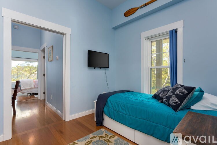 A bedroom with a bed, a TV, and a window.