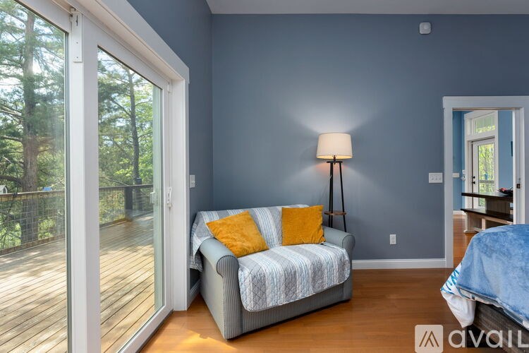 A living room with a grey couch and a lamp.