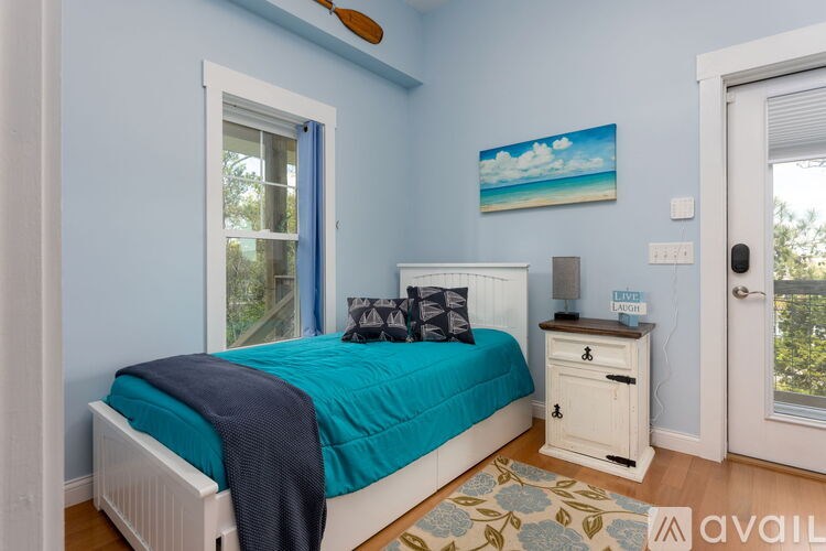 A bedroom with a bed, nightstand, and window.