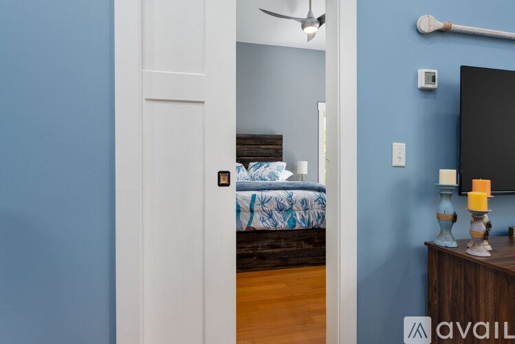 A bedroom with a bed, a dresser, and a ceiling fan.