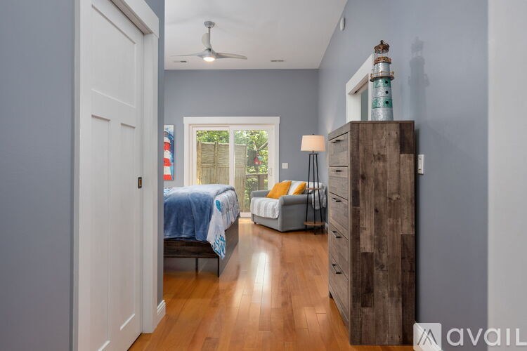 A bedroom with a bed, a couch, and a wooden dresser.