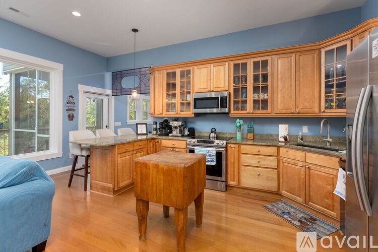 A kitchen with wooden cabinets and a blue sofa.