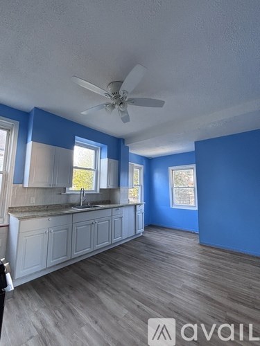 A kitchen with blue walls and wooden floors.