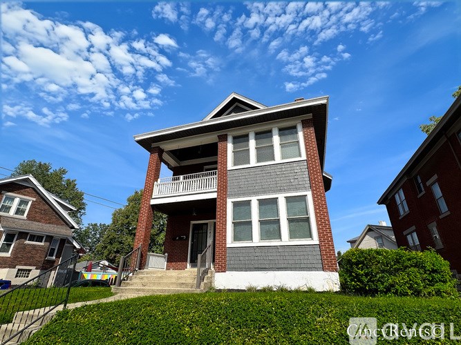 A two-story house with a balcony on the second floor.