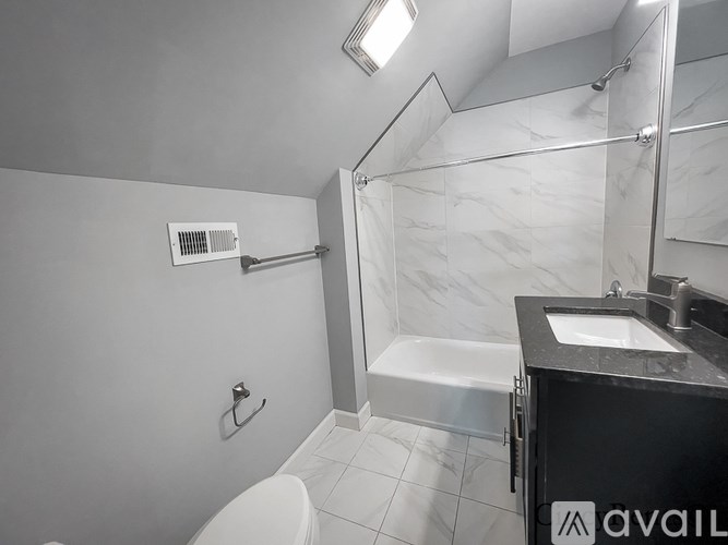 A bathroom with a white toilet, a sink, and a walk-in shower.