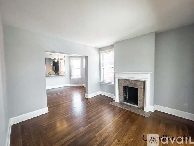 A living room with a fireplace and wood flooring.