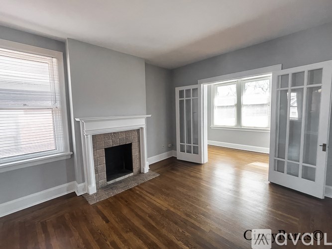 A room with a fireplace and wooden floors.