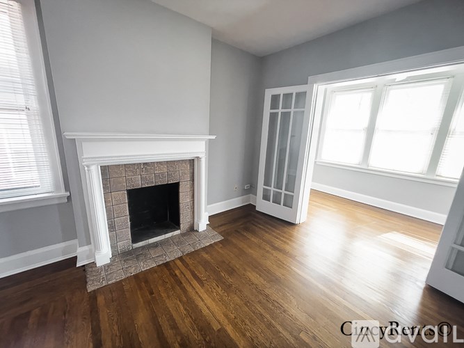 A room with a fireplace and wooden floors.