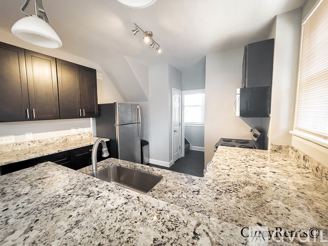 A kitchen with granite countertops and a refrigerator.