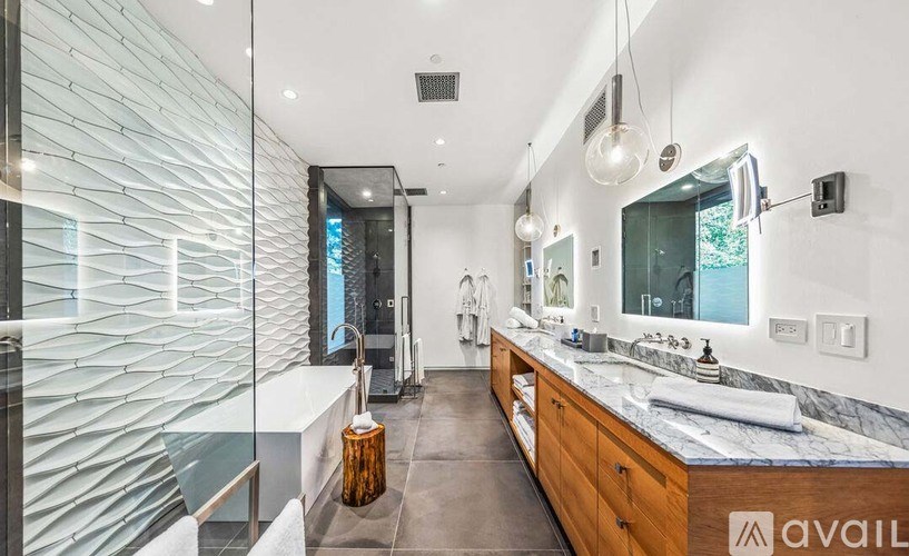 A modern bathroom with a marble countertop and a large mirror.