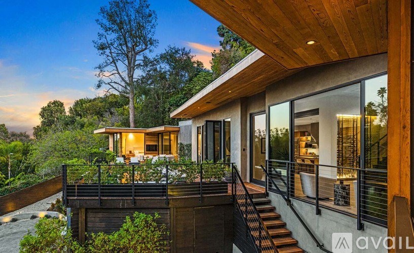 A modern house with a wooden deck and glass windows.