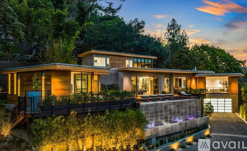 A modern house with a pool in front is available for sale.