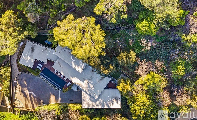 A house surrounded by trees in an aerial view.