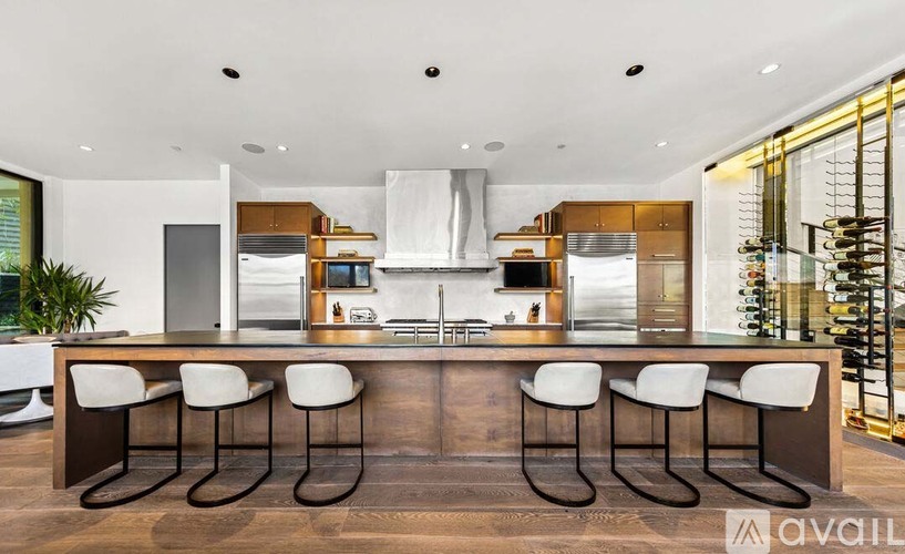 A modern kitchen with a long island and bar stools.