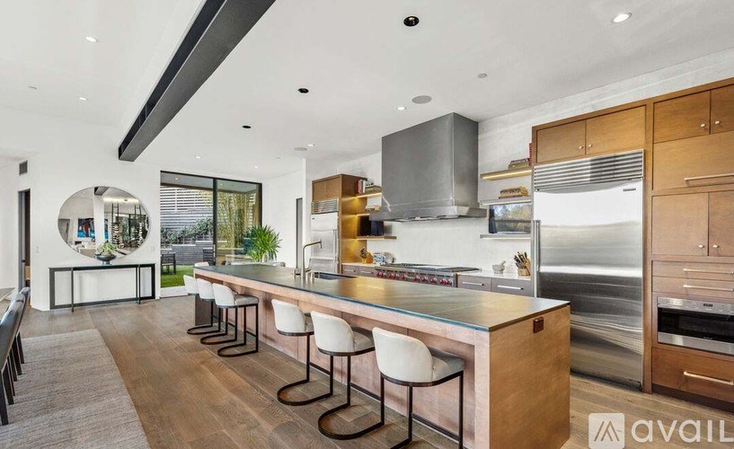 A modern kitchen with a long island and stainless steel appliances.