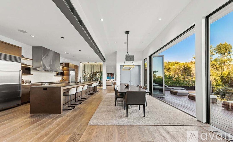 A modern kitchen with a dining area and a view of the outdoors.