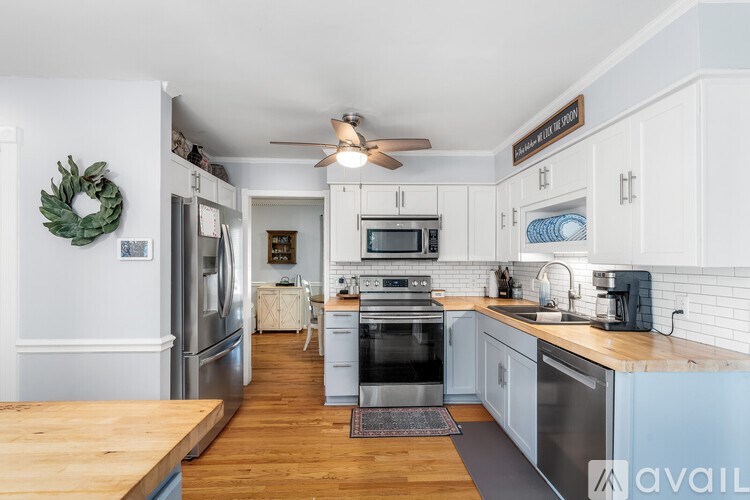 A kitchen with a wooden floor and a wreath on the wall.