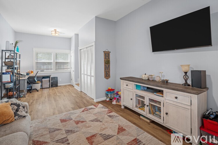 A living room with a grey couch and a wooden cabinet.