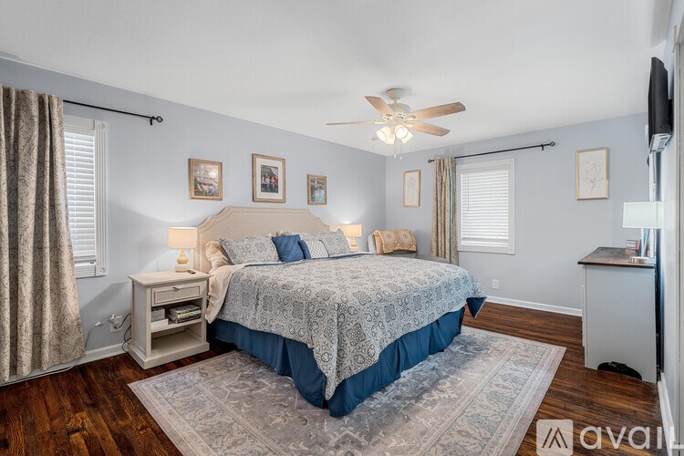 A bedroom with a bed, nightstand, and a ceiling fan.