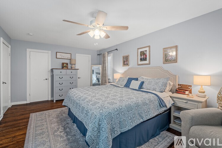 A bedroom with a large bed and a ceiling fan.