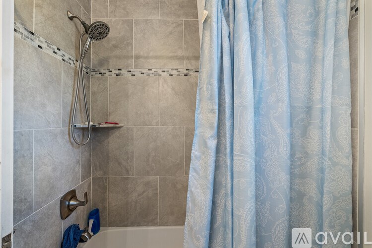 A shower area with a blue shower curtain.