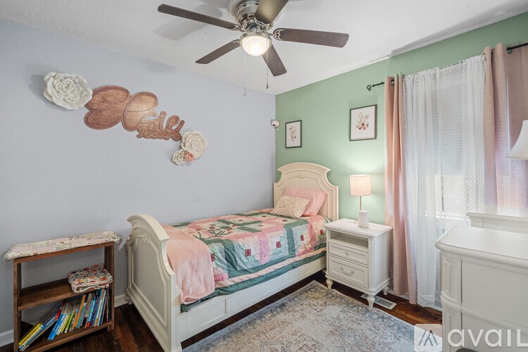 A bedroom with a bed, nightstand, and a ceiling fan.