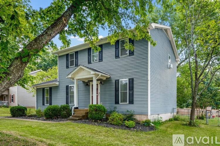 A house with a blue siding and a white porch.