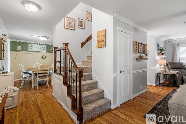 A living room with a staircase and a dining table.