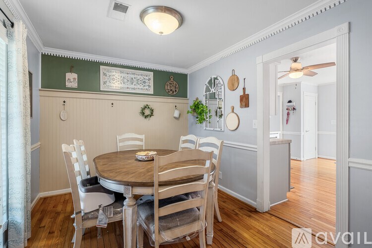 A dining room with a round table and chairs.