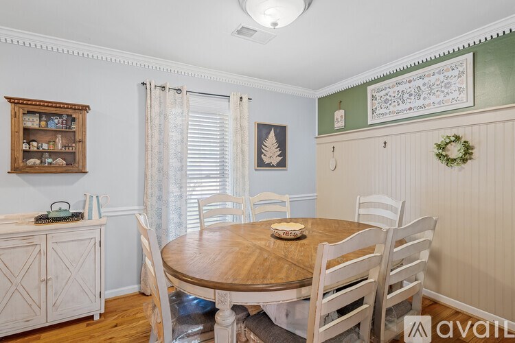 A dining room with a wooden table and chairs.