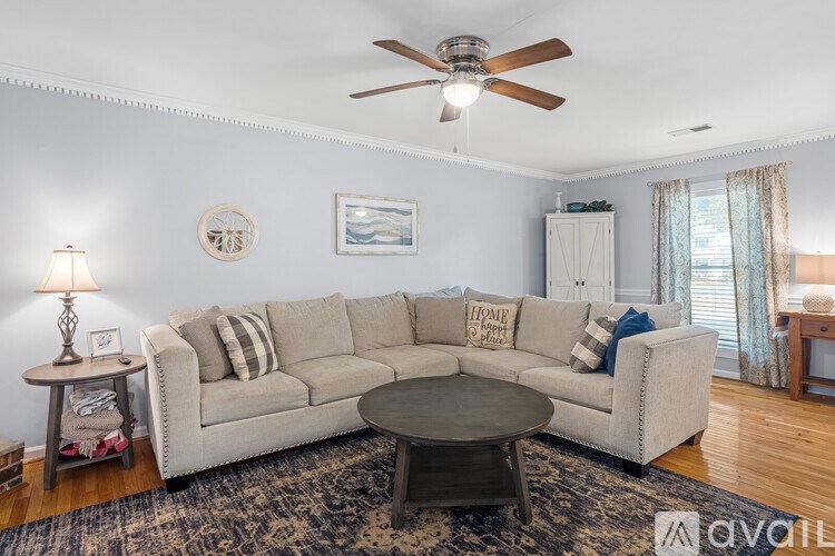 A living room with a white couch and a ceiling fan.