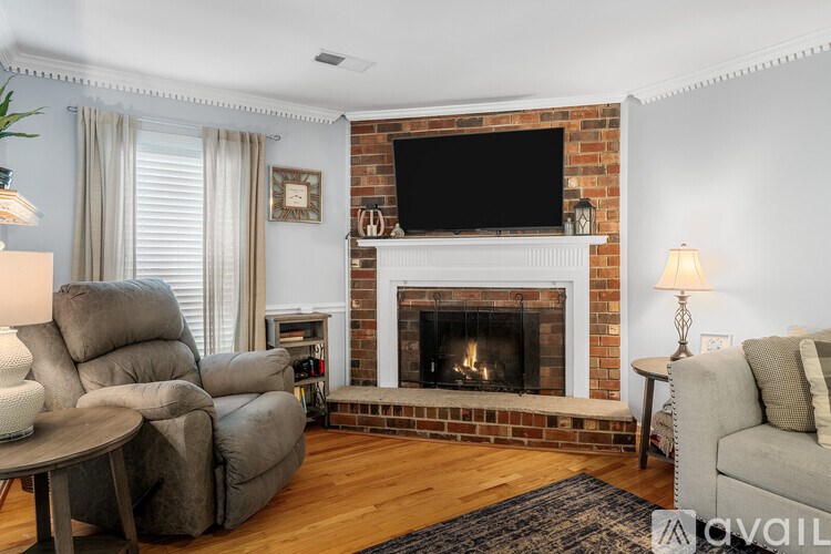 A living room with a fireplace and a television above it.