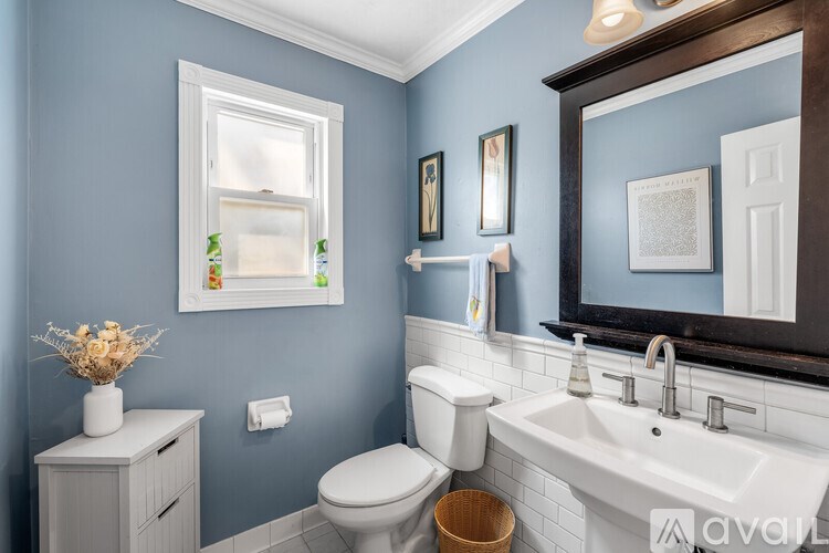 A bathroom with blue walls and a white toilet.
