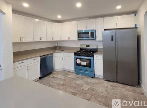 A kitchen with white cabinets and a blue oven.