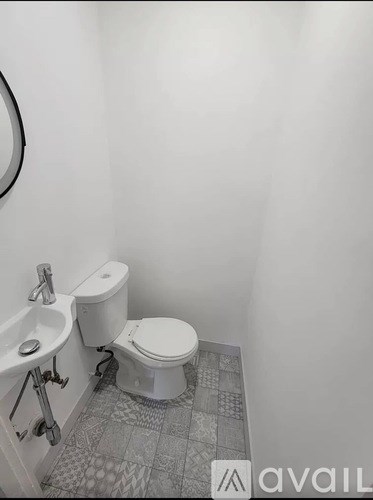 A white toilet sits next to a sink in a small bathroom.