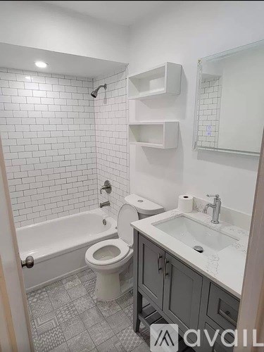 A white toilet is in a bathroom with a white sink.