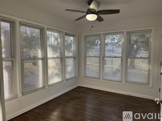 A room with a ceiling fan and sliding glass doors.