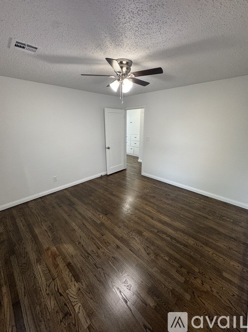 A room with wooden flooring and a ceiling fan.