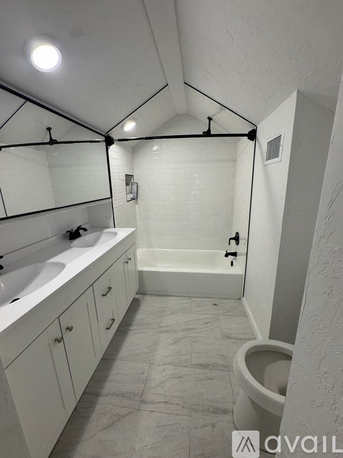 A bathroom with a toilet, sink, and bathtub.