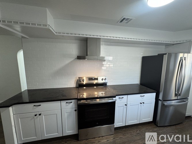 A kitchen with black countertops and white cabinets.
