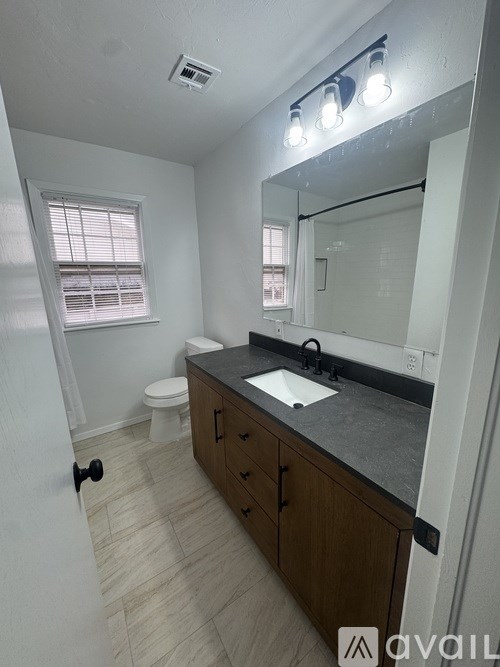 A bathroom with a sink, mirror, and toilet.