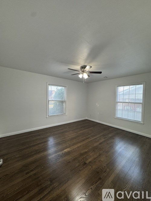 A room with wooden floors and a ceiling fan.