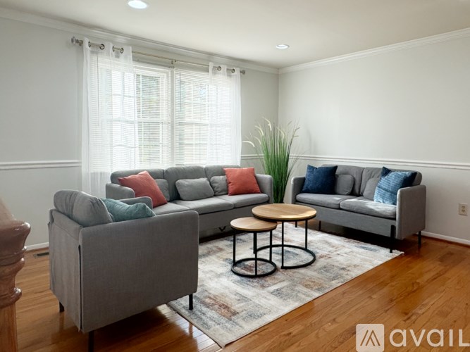 A living room with a grey couch, a small table, and a rug.
