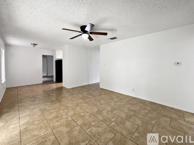 A room with a ceiling fan and tiled flooring.