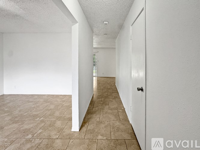 A long hallway with tiled floors and white walls.