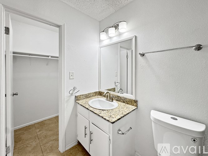 A bathroom with a sink, mirror, and toilet.