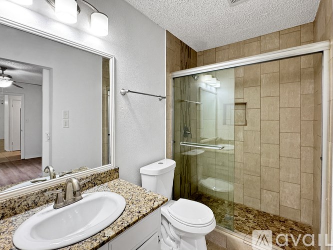 A bathroom with a sink, toilet, and shower.