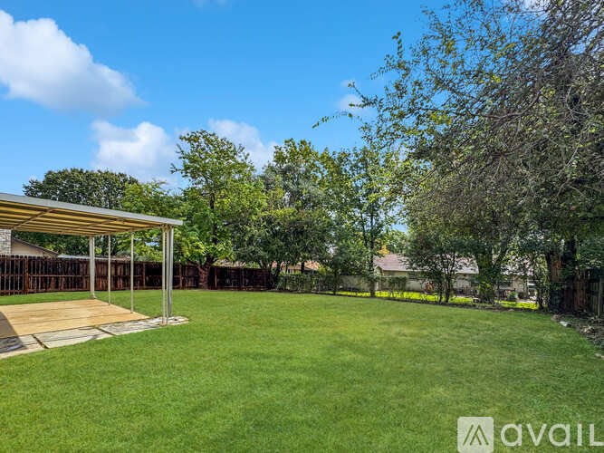 A backyard with a wooden deck and a well-maintained lawn.