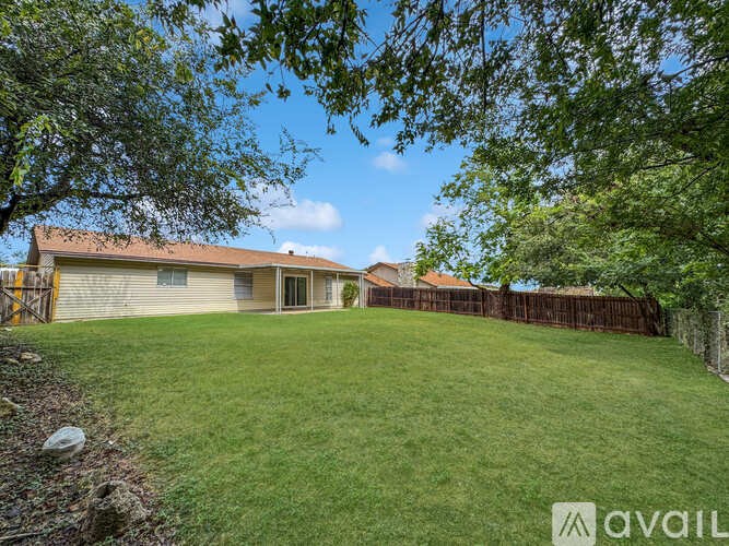 A house with a yard and a fence is for sale.