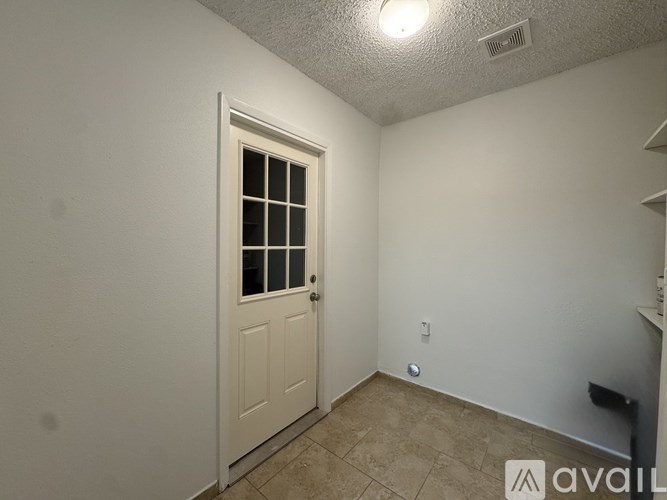 A room with a white door and a tiled floor.